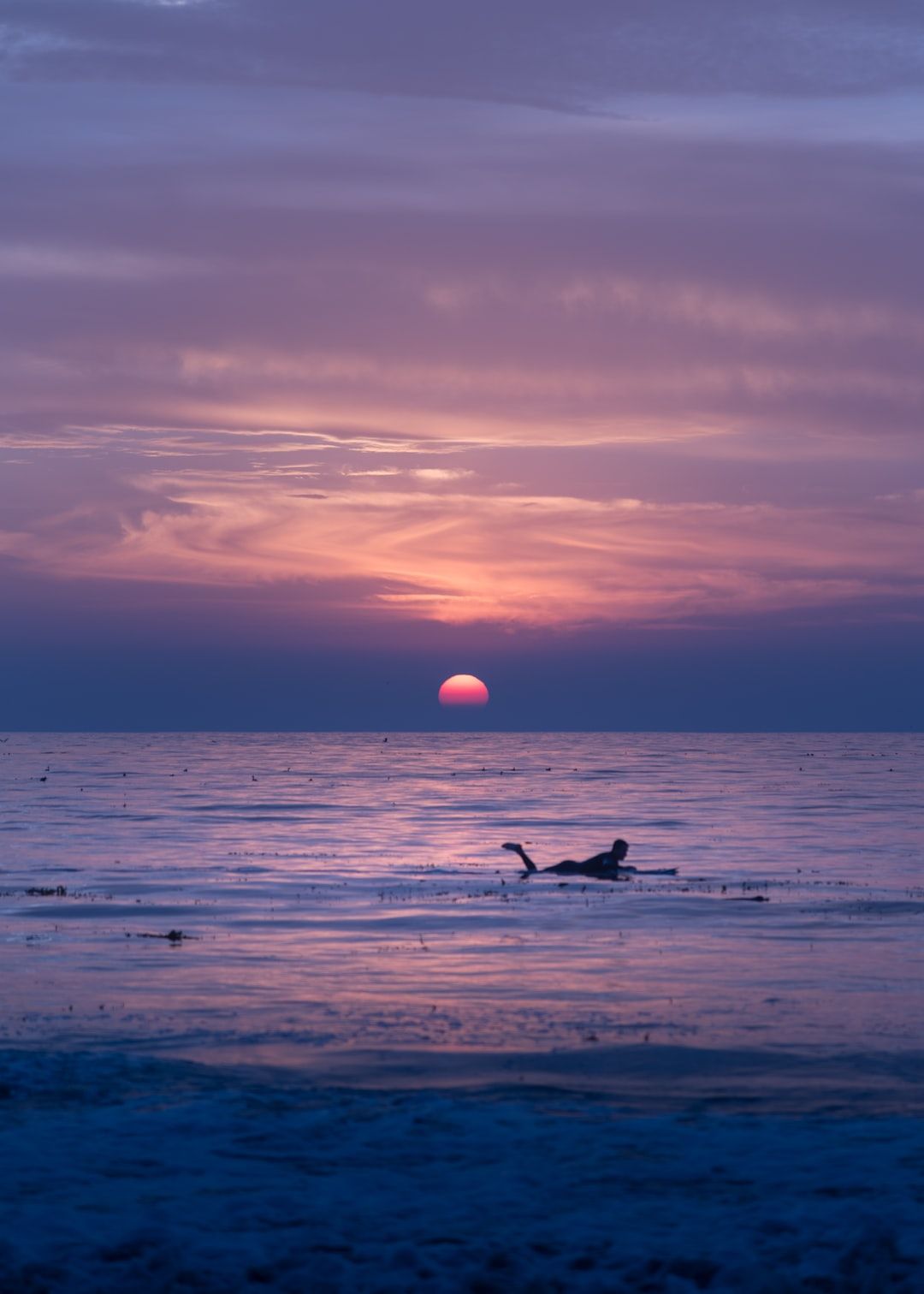 As hundreds of people stood mesmerized by this sunset at Carmel-by-the-Sea, this lone swimmer with a paddleboard waded through the waters. I was looking for a subject to freeze this frame and this made a perfect opportunity.